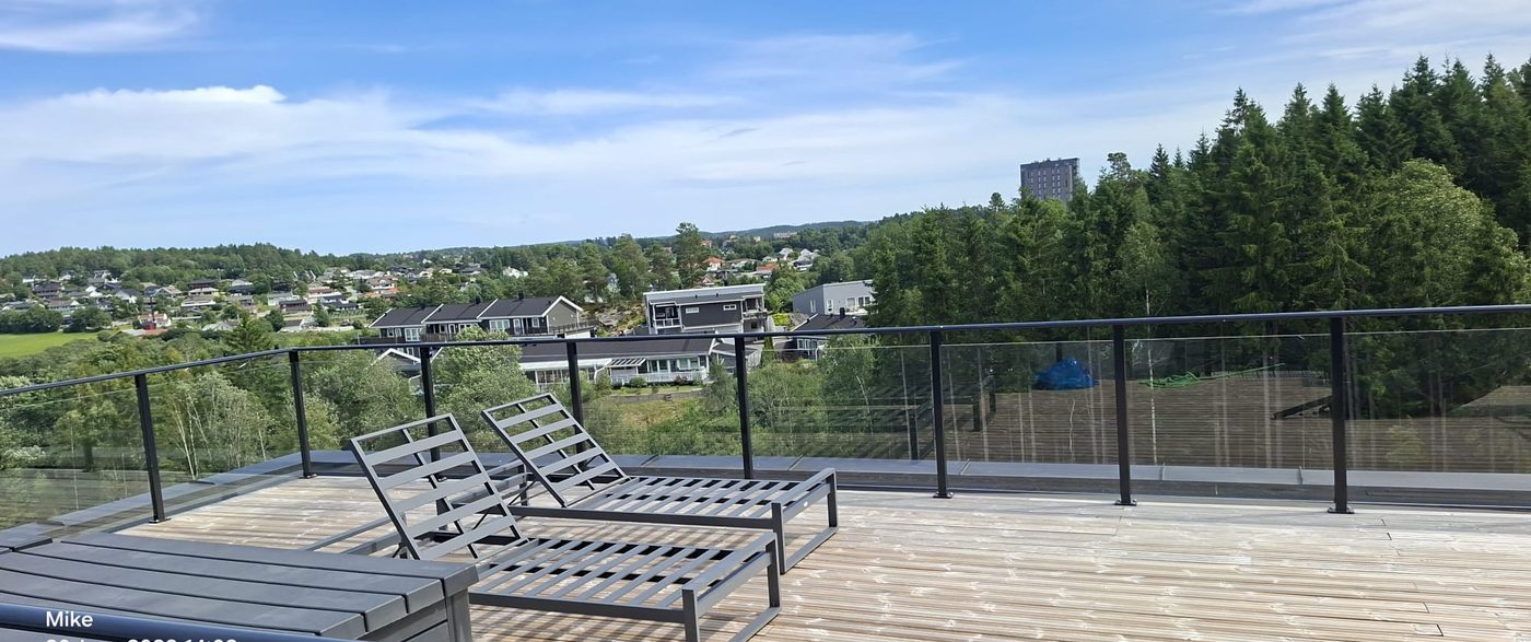Takterrasse med solstoler og glassrekkverk